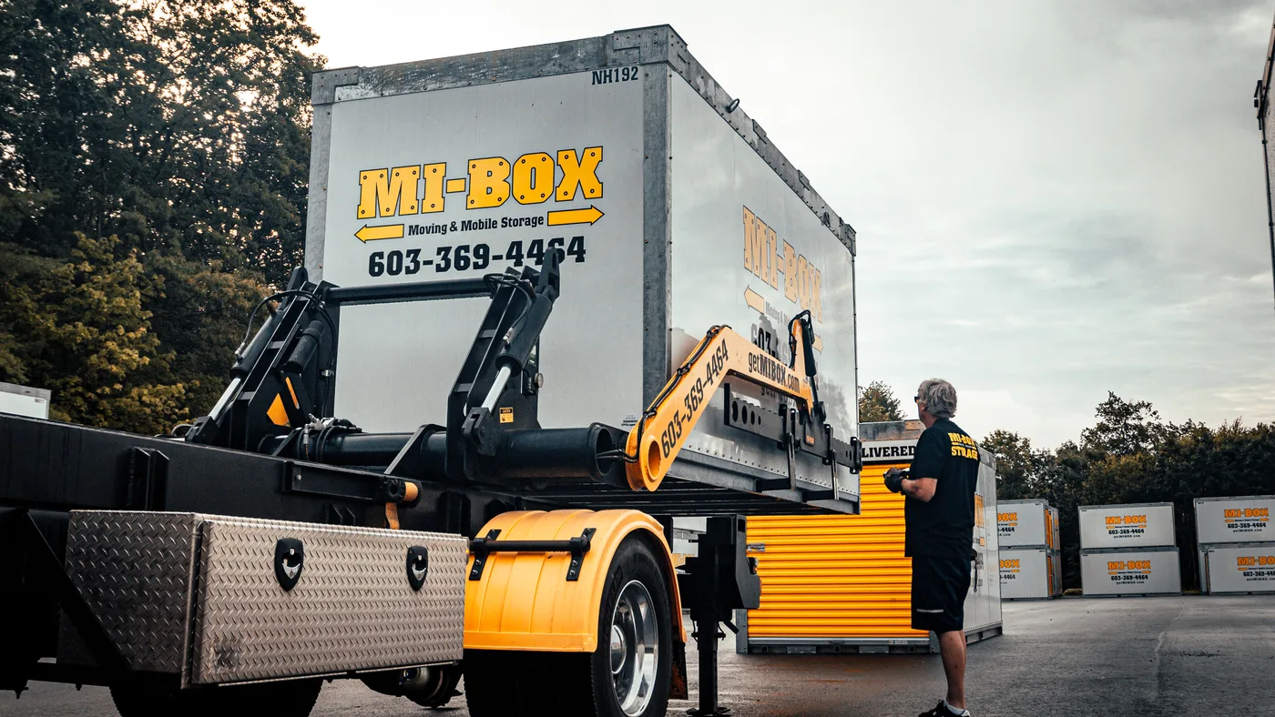 MI-BOX driver operating the LeveLift storage container delivery system in NH