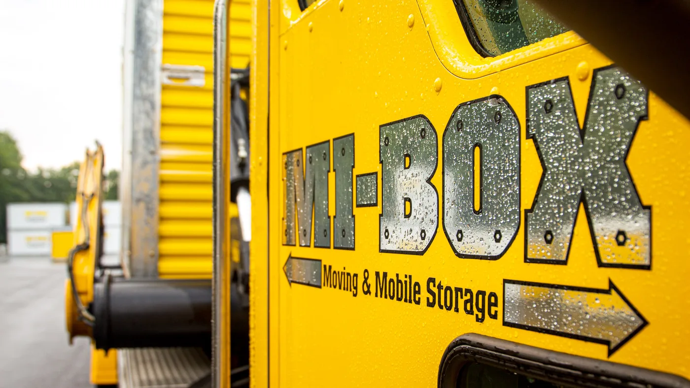 MI-BOX LeveLift delivery truck bringing a portable storage container to a New Hampshire jobsite