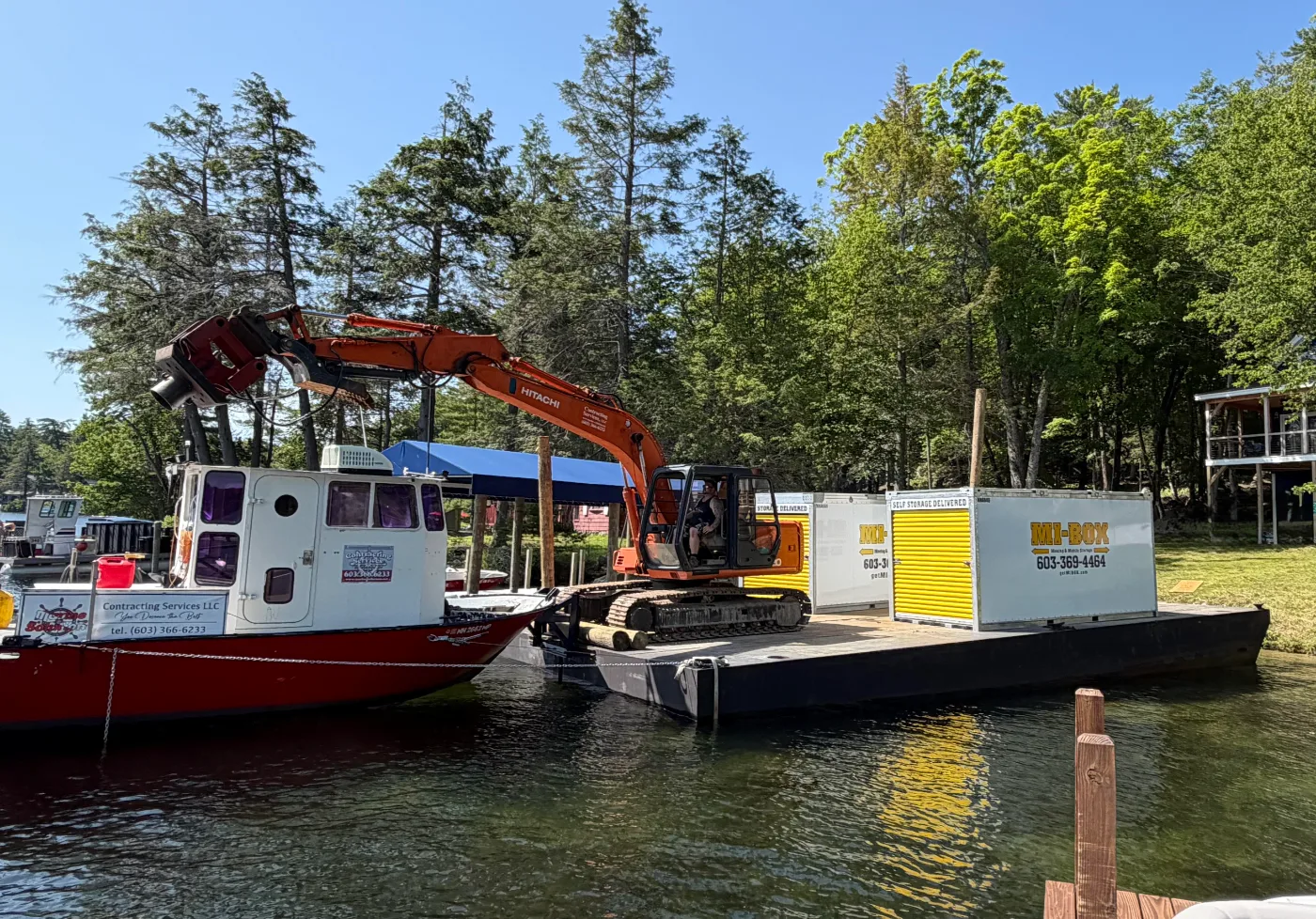 MI-BOX portable storage container and excavator staged on a Contracting Service Company barge for delivery to a Lake Winnipesaukee island property