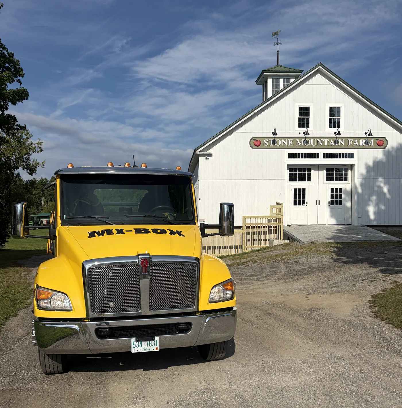 MI-BOX portable storage delivery truck parked beside a barn at a New Hampshire farm
